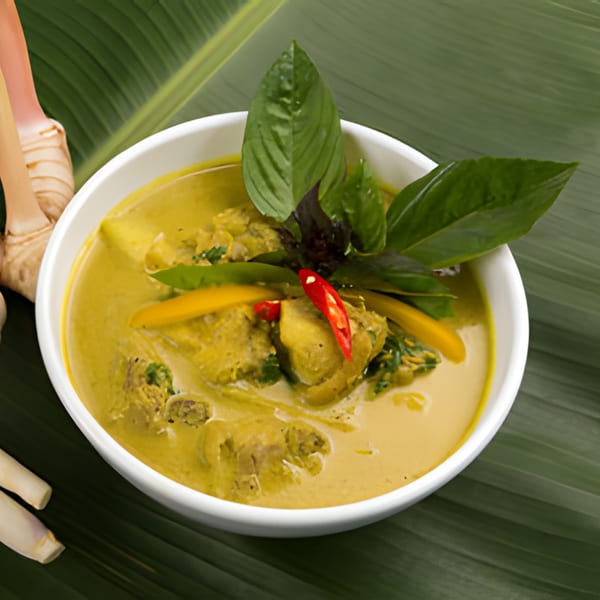 BAITONG Thai & Sushi Bar's green curry with chicken, basil, and red chili on a banana leaf.