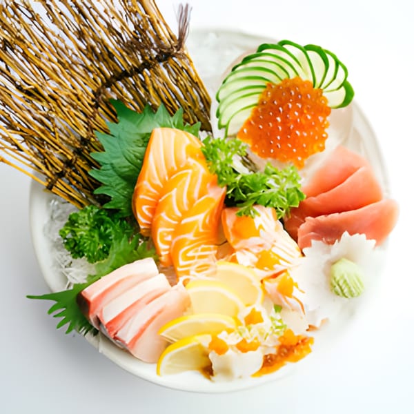 A vibrant sashimi platter with salmon, tuna, yellowtail, roe, cucumber, and lemon slices.