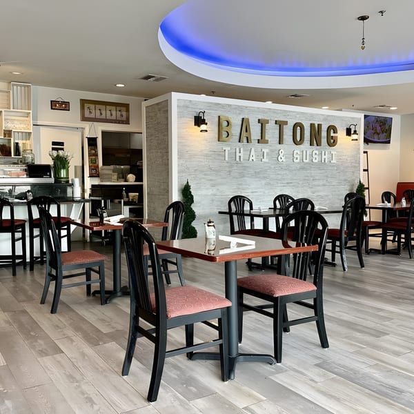 Interior of BAITONG Thai & Sushi Bar, featuring dining tables, chairs, and a counter area.